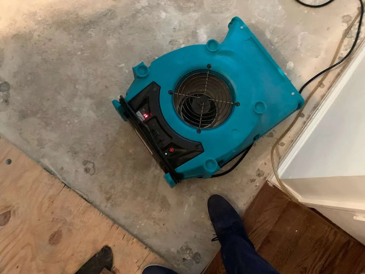 Air mover drying subfloor during Commercial Water Damage Restoration in Attleboro